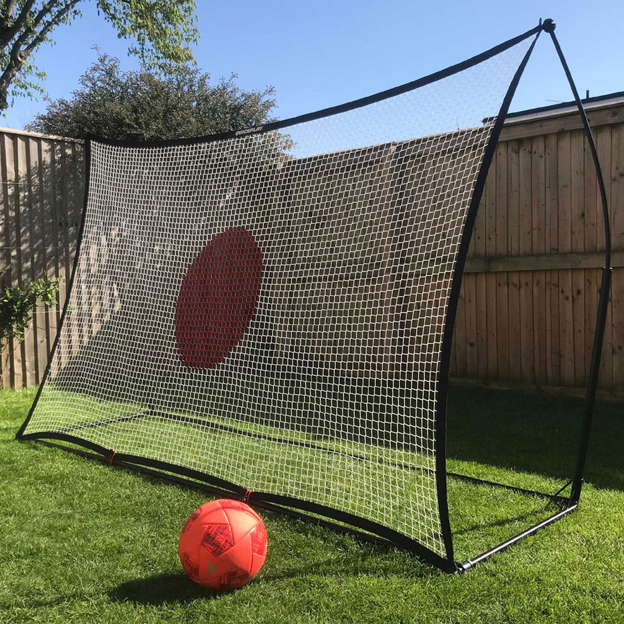 SPOT Football Rebounder 8x5' with a white net and red target circle in a garden, with an orange ball in front.